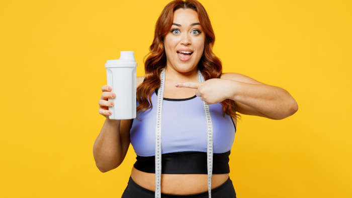 Abnehmshake aus Molkenprotein, gezeigt von übergewichtiger Frau