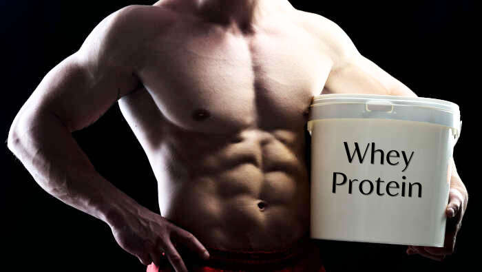 Bodybuilder mit einer großen Dose Whey Protein oder Molkenprotein