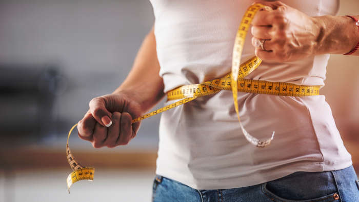 Bandmaß um Taille - Kaloriendefizit zum Abnehmen macht schlanker