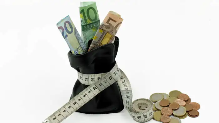 Geldscheine in einem Beutel, der von einem Maßband zusammengehalten wird